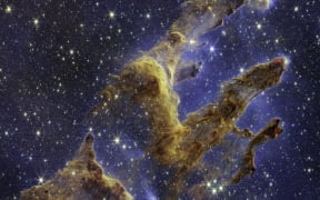 This handout photo provided by NASA on October 19, 2022 shows the Pillars of Creation that are set off in a kaleidoscope of color in NASA’s James Webb Space Telescope’s near-infrared-light view. - The pillars look like arches and spires rising out of a desert landscape, but are filled with semi-transparent gas and dust, and ever changing. This is a region where young stars are forming – or have barely burst from their dusty cocoons as they continue to form. (Photo by Handout / NASA/ESA/CSA / AFP) / RESTRICTED TO EDITORIAL USE - MANDATORY CREDIT "AFP PHOTO / NASA/ESA/CSA " - NO MARKETING NO ADVERTISING CAMPAIGNS - DISTRIBUTED AS A SERVICE TO CLIENTS