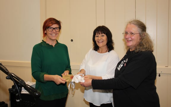 Greens Party senior citizens' spokesperson Jan Logie receiving a copy of the report, In Safe Hands? from Sacha Young (in white) and Marianne Bishop, of the National Aged Care Delegates Committee.