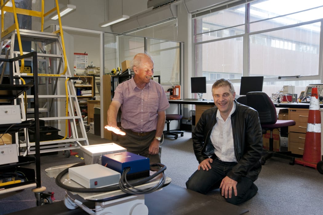 The wireless power concept from a roadway to a vehicle (lighting a light) with John (left) and Grant (right)