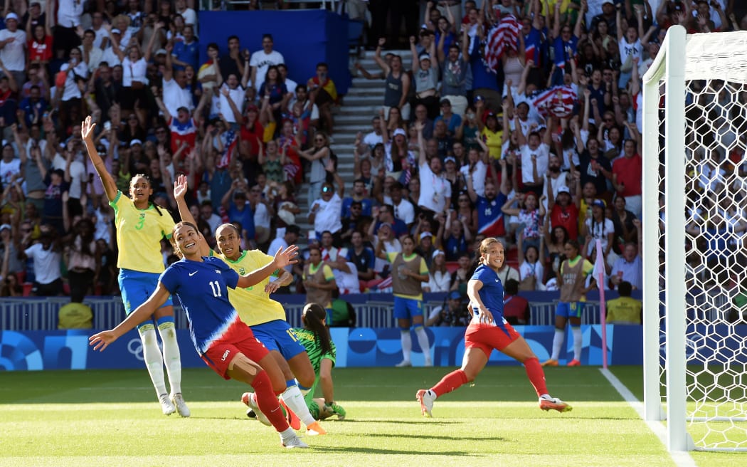 Mallory Swanson dari AS mencetak gol saat bek Brasil mengklaim offside di Olimpiade Paris 2024.