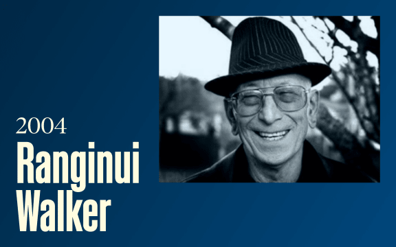 An older man wearing slightly tinted large glasses and a hat smiles, text reads "2004, Ranginui Walker"