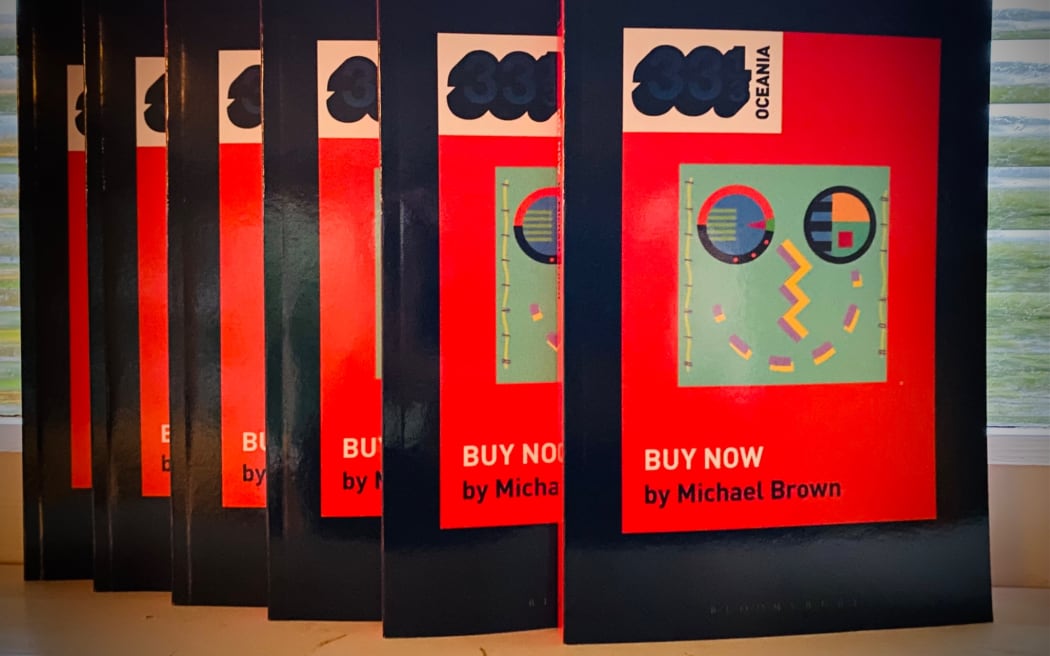 A stack of books with the album 'Buy Now' by Eyeliner on their cover.