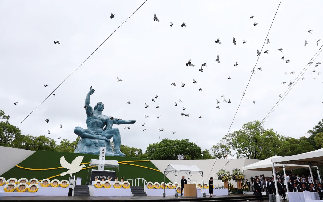 Doves fly past a "Peace Statue" at the Peace Park in Nagasaki after being released during a memorial ceremony on 9 August, 2025, to mark the 80th anniversary of the atomic bombing during WWII.