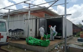 Health workers moving body bags at Goroka Hospital's morgue. October 2021.