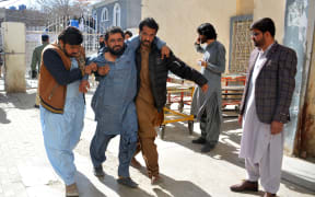 A bomb blast victim  is helped to walk into a hospital in Quetta on February 7, 2024. At least 22 people were killed Wednesday in two separate bomb blasts outside poll candidate offices in southwestern Pakistan, officials said, on the eve of an election marred by violence and allegations of poll-rigging (Photo by AFP)