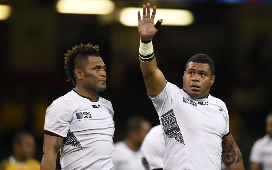 Flying Fijians prop Isei Colati [R] waves goodbye to the Rugby World Cup.