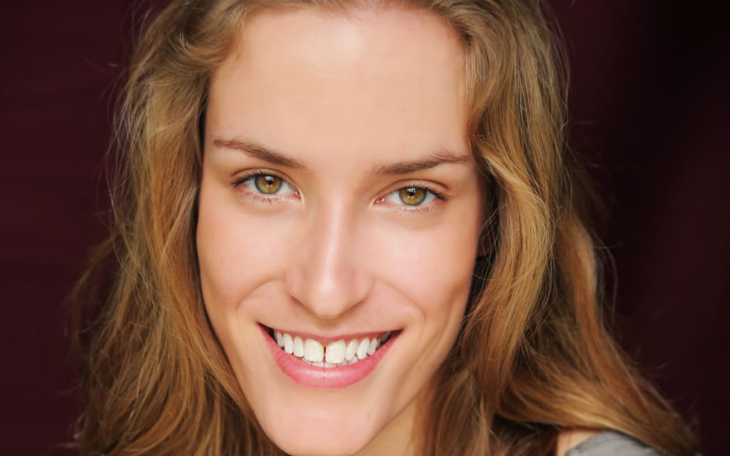 Author photo of smiling woman with light brown hair and eyes