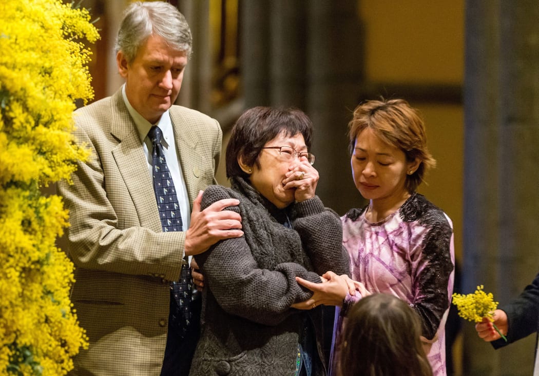 A grieving family member is pictured as wattle blossoms are placed onto a wreath during a national day of mourning service for the victims of Malaysia Airline MH17 St. Patrick’s Cathedral in Melbourne.