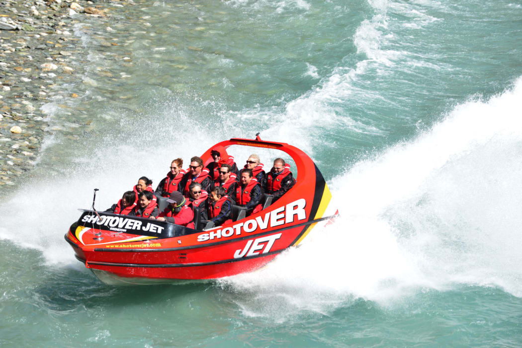 Tourists enjoy a high-speed boat ride on Queenstown