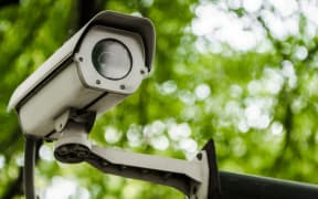 A closed-circuit television camera on green nature background.