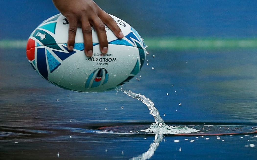 A rugby ball is seen in a puddle of rainwater during South Africa's Captain's Run session at the International Stadium Yokohama in Yokohama on October 25, 2019, ahead of the Japan 2019 Rugby World Cup semi-final match against Wales. (Photo by Odd Andersen / AFP)