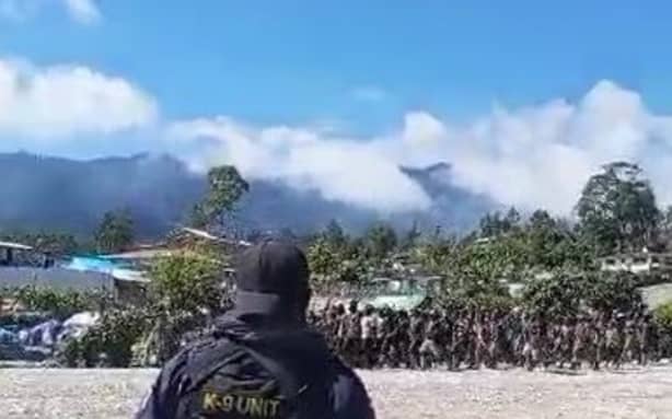 Papua New Guinea K-9 Unit member guards at the Porgera mining site as protesters from warring tribes gather. September 2024