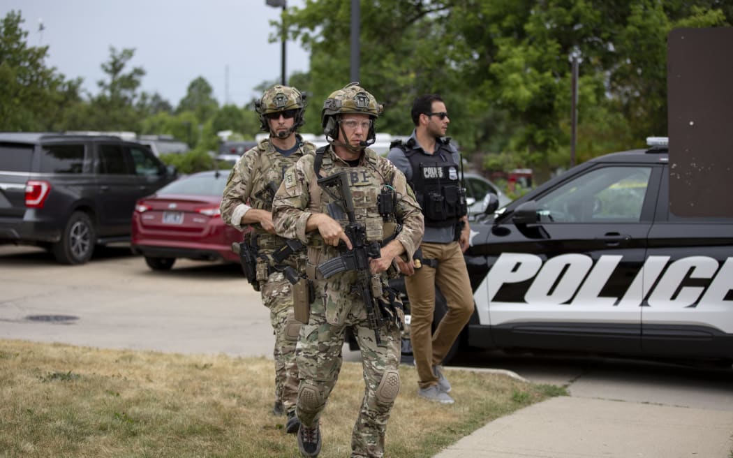 Law enforcement officers at scene of a mass shooting at a Fourth of July parade in Highland Park, Illinois.