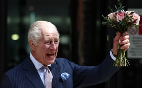 Britain's King Charles III, holding a bunch of flowers, waves to crowds after to visit to the University College Hospital Macmillan Cancer Centre in London on April 30, 2024. Charles is making his first official public appearance since being diagnosed with cancer, after doctors said they were "very encouraged" by the progress of his treatment. (Photo by HENRY NICHOLLS / AFP)