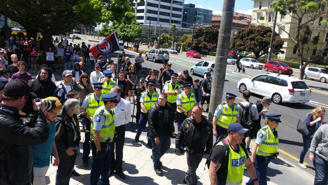 Police escort National Front members away from Parliament.