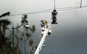 An electrical worker repairs traffic lights in Naples, Florida after Hurricane Irma swept through on 11 September, 2017.