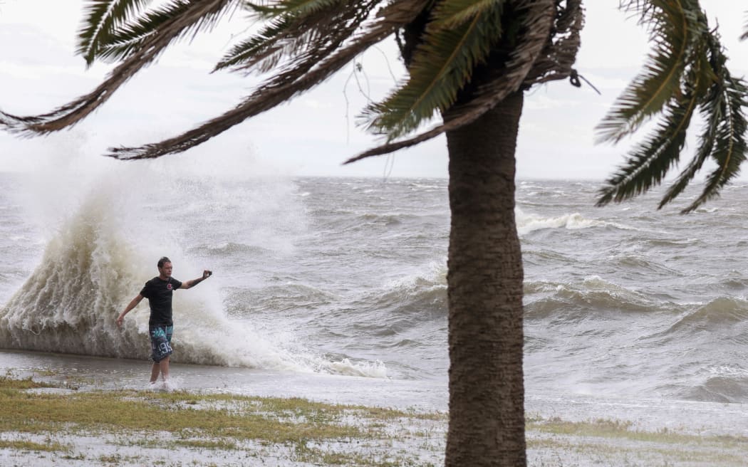 ST. PETERSBURG, FLORIDA - SEPTEMBER 26: Tayze Belcher stands near as a wave crashes ashore as Hurricane Helene passes offshore on September 26, 2024, in St. Petersburg, Florida. Helene is forecast to become a major hurricane, bringing the potential for deadly storm surges, flooding rain, and destructive hurricane-force winds along parts of the Florida West Coast.   Joe Raedle/Getty Images/AFP (Photo by JOE RAEDLE / GETTY IMAGES NORTH AMERICA / Getty Images via AFP)