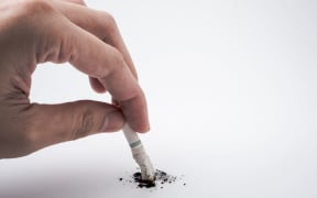 A hand push the cigarette stub on white background, Symbolic stop / quit smoking concept, Free space for text
