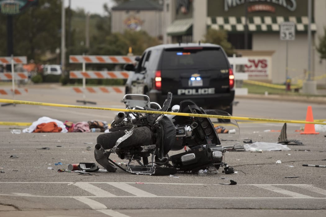 A wrecked police motorcycle lays on the scene after a suspected drunk driver crashed into a crowd of spectators at Oklahoma State University.