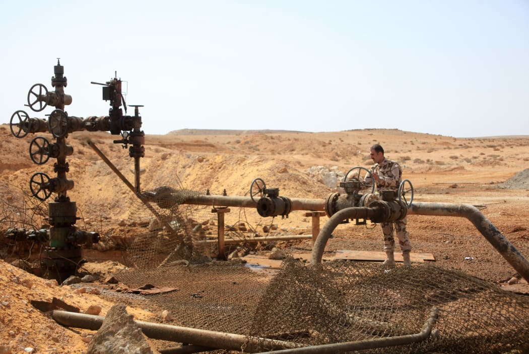 A member of the Syrian government forces stands next to a well at an oil field near Palmyra after retaking it from IS in March 2015.