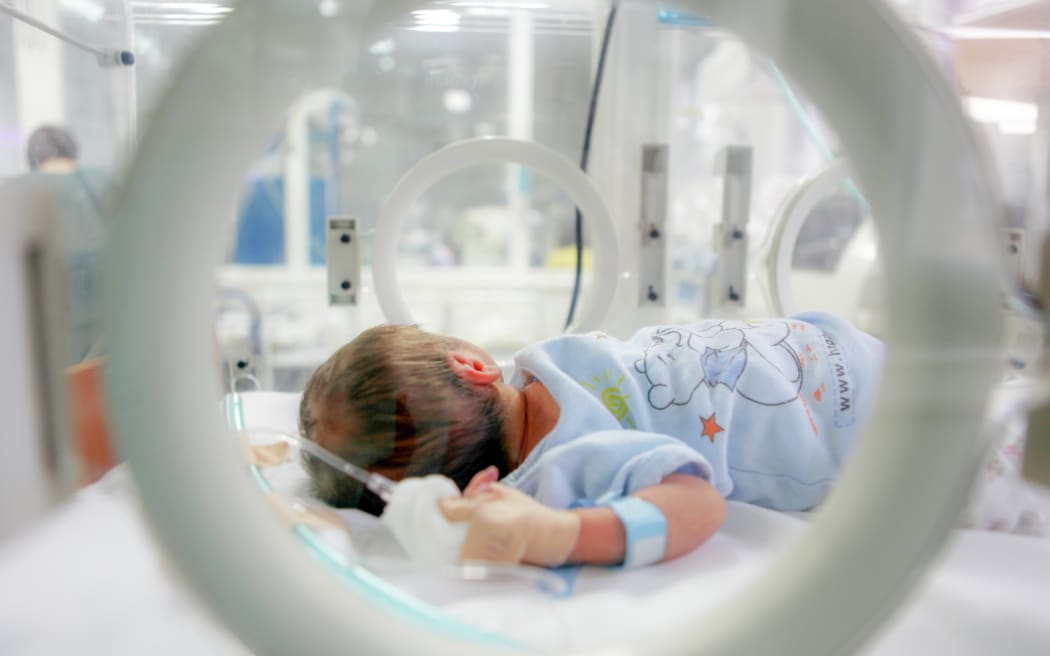 Newborn baby in hospital. Baby care unit.