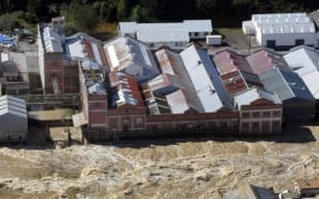 The flooded Mataura River rips past the former Mataura paper mill