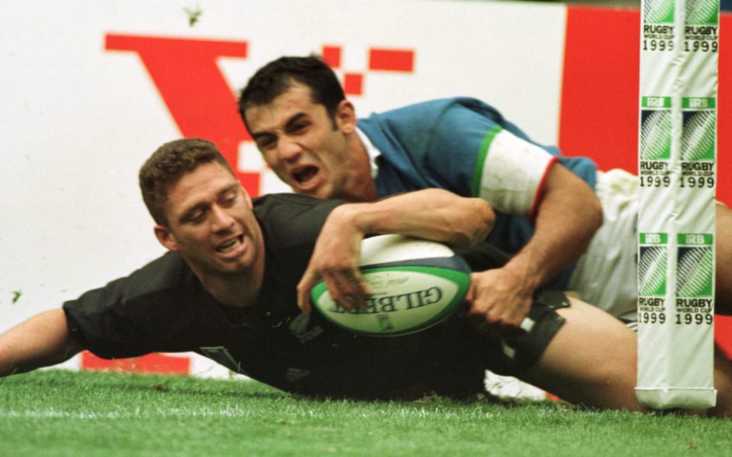 Glen Osborne slides in the tackle of Italy's Christian Stocia to score in the final pool match of the Rugby World Cup at McAlpine Stadium, Huddersfield.