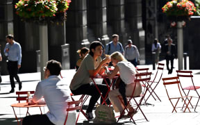 People spend their lunch hour in the central business district of Sydney on November 3, 2020. (Photo by Saeed KHAN / AFP)