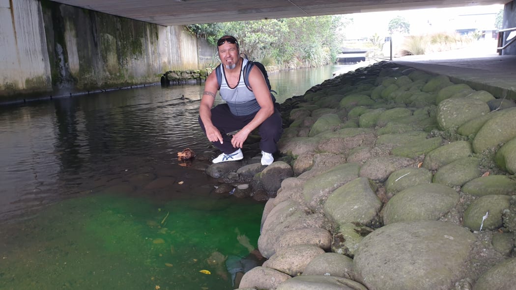 Aaron Tainui at the site of a luminous green discharge into the Huatoki Stream.