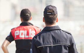 Two Turkish police officers stand with their backs to the camera in Istanbul in 2013 (file photo)