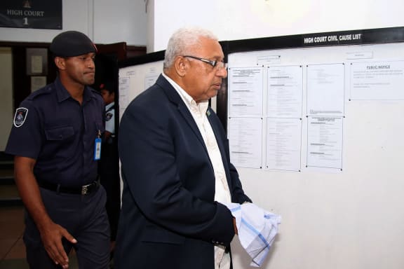 Former Fiji prime minister Frank Bainimarama wearing handcuffs leaves the court building after receiving his sentence in Suva on May 9, 2024. Bainimarama was sentenced on May 9 to one year in prison for perverting the course of justice, with a judge finding he used his political clout to shut down a police investigation. (Photo by Kunal KESHNEEL / AFP)