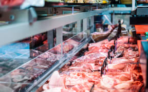 Fresh raw red meat at the butcher in refrigerated display