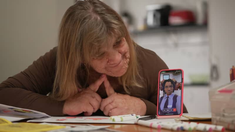 Hayley smiles at Miles on her phone.