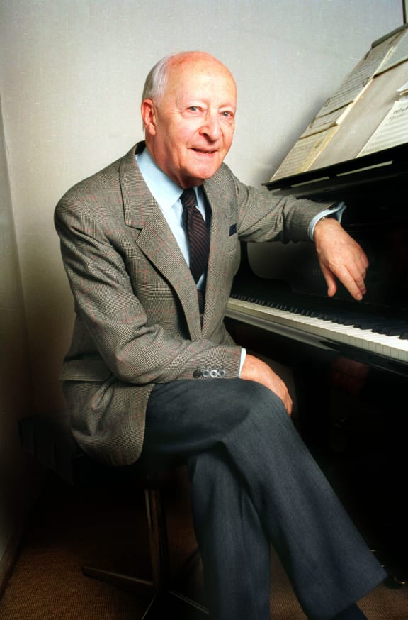Polish composer Witold Lutosławski sitting at a piano