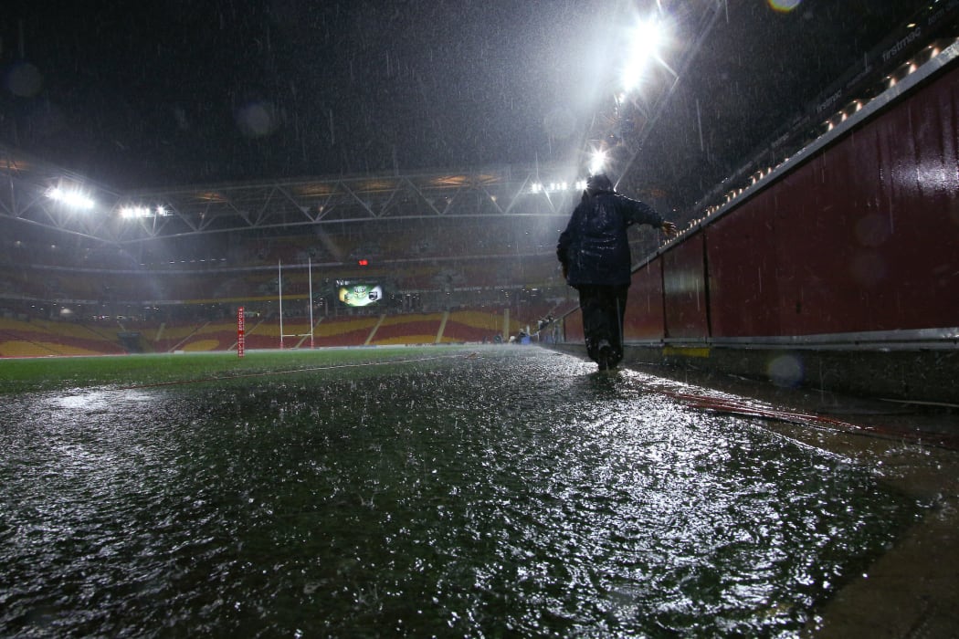 A  security guard walks off a flooded Suncorp Stadium  following the postponement of the ANZAC Test to Sunday 3rd May, Brisbane ,Australia on May 1, 2015.