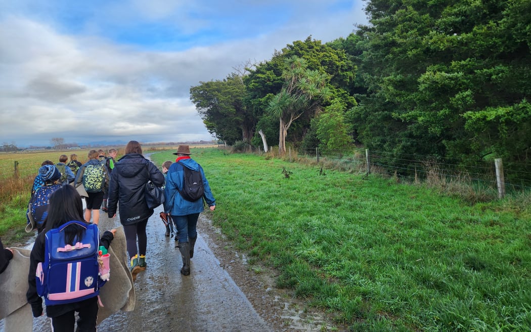 The class heads towards the forest block on Waihinga Farm with Jane Riddiford of the Ruamāhanga Farm Trust