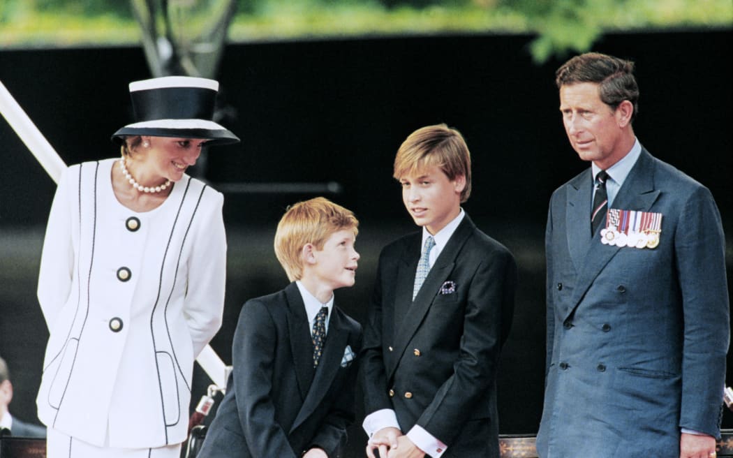 Prince Charles (L), Princess Diana (R) and their children William (2nd L) and Harry watch the march past on a dais on the mall as part of the commemorations of VJ Day on August 19, 1995. The commemoration was held outside Buckingham Palace and was attended by 15,000 veterans and tens of thousands of spectators. (Photo by Johnny EGGITT / AFP)