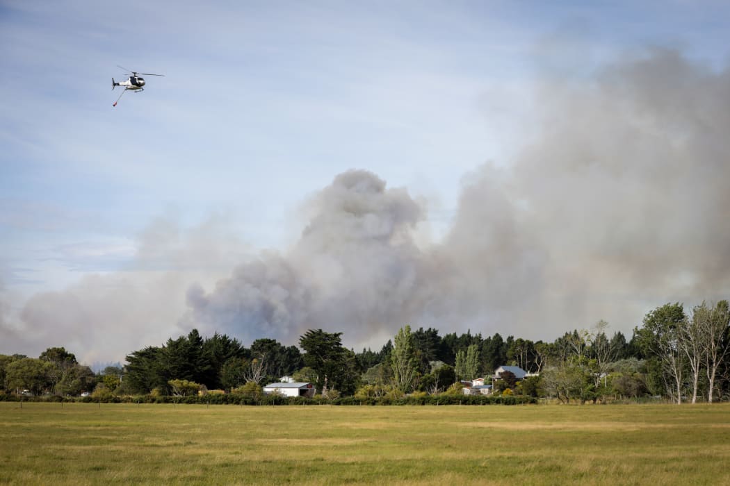 Fire nears a house at Pine Beach, just north of Christchurch.