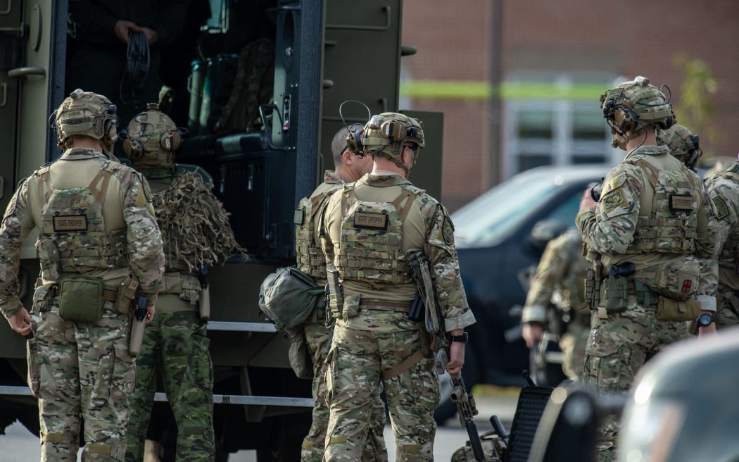 Law enforcement officers gather outside Lewiston High School, Maine on October 26, 2023. A massive manhunt was under way for a gunman wanted for murder after 18 people were killed in a mass shooting in Maine.