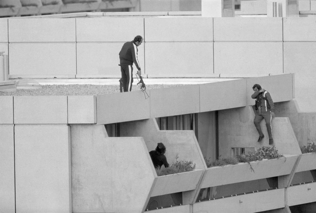 Armed police drop into position on a terrace directly above the apartments where between nine and 26 members of the Israeli Olympic team are being held hostage 9/5 by Arab "Black September" extremists.