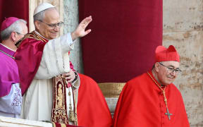 Newly elected Pope Leo XIV, Robert Francis Prevost (C) gestures as he addresses the crowd from the main central loggia balcony of the St Peter's Basilica for the first time, after the cardinals ended the conclave, in The Vatican, on May 8, 2025. Robert Francis Prevost was on Thursday elected the first pope from the United States, the Vatican announced. A moderate who was close to Pope Francis and spent years as a missionary in Peru, he becomes the Catholic Church's 267th pontiff, taking the papal name Leo XIV. (Photo by Andrej ISAKOVIC / AFP)
