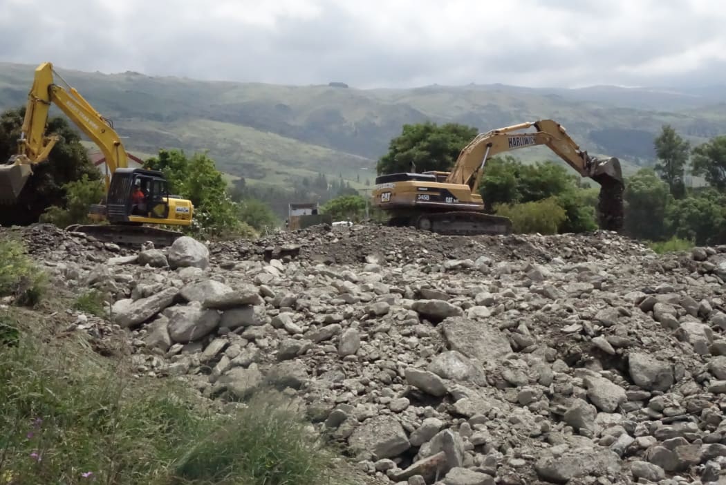 Diggers work in Roxburgh's Reservoir Creek drainage in a race against time before next the downpour.