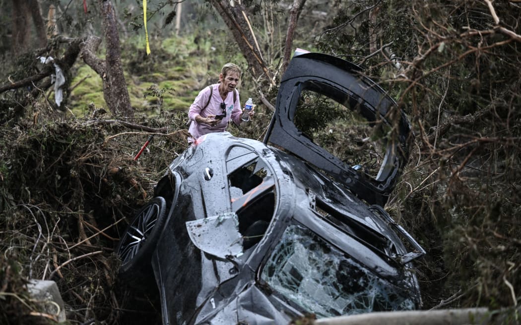 A volunteer looks for missing people, following severe flash flooding that occured during the July 4 holiday weekend, in Hunt, Texas, on July 6, 2025. Rescuers in Texas raced against time Sunday to find dozens of missing people, including children, swept away by flash floods that killed at least 59, as forecasters warned of new deluges. Local Texans joined forces with disaster officials to search through the night for the missing, including 27 girls from a riverside Christian summer camp. Texas Governor Greg Abbott said Camp Mystic on the banks of the Guadalupe River, where some 750 girls had been staying when the floodwaters hit, had been "horrendously ravaged in ways unlike I've seen in any natural disaster." (Photo by RONALDO SCHEMIDT / AFP)
