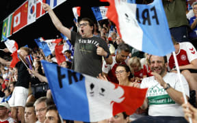 Supporters of France's Toma Junior Popov celebrate his win against Indonesia's Anthony Sinisuka Ginting in their men's singles badminton group stage match during the Paris 2024 Olympic Games at Porte de la Chapelle Arena in Paris on July 31, 2024. (Photo by Luis TATO / AFP)