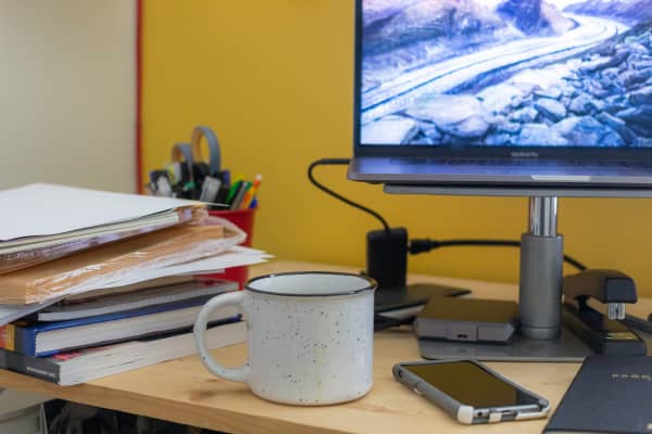 Books, papers, mug and phone on an office desk.