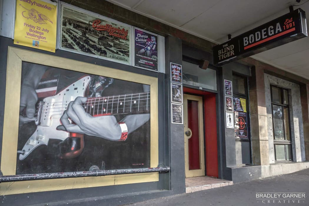 The front of Bodega in 2016. Photo by Bradley Garner. Wall mural of Andrew Wilson from Die! Die! Die! by NZ artist Mark Rutledge.