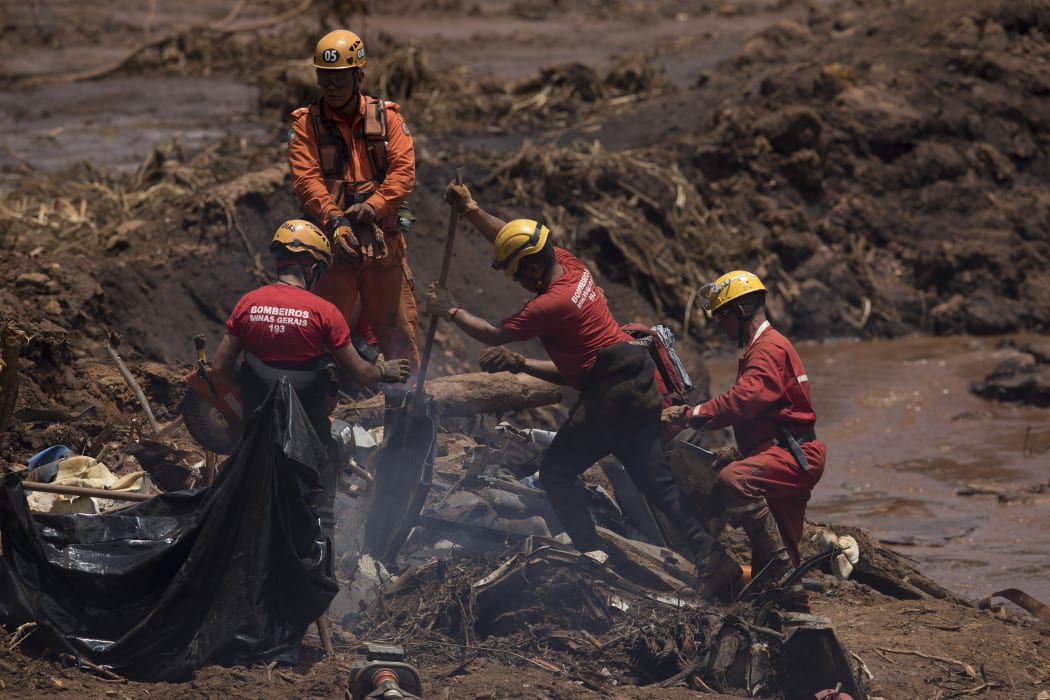 Firefighters looks for victims inside a vehicle days after a dam collapse in Brumadinho, Brazil, Monday, Jan. 28, 2019. Firefighters on Monday carefully moved over treacherous mud, sometimes walking, sometimes crawling, in search of survivors or bodies four days after the collapse.
