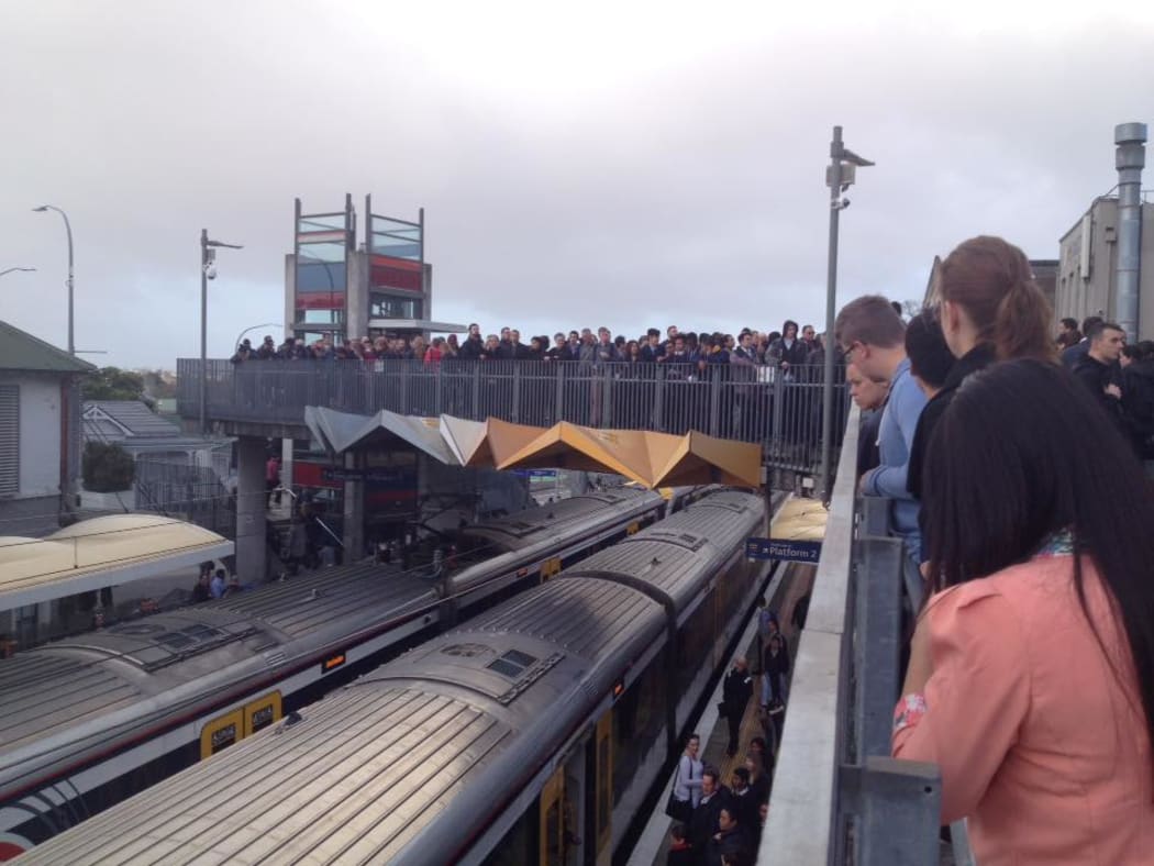 Train passengers crowd onto an overbridge at Kingsland Station.