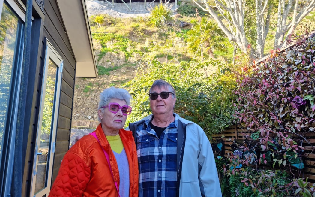 Julie Ambrose and Geoff Moffett with the exposed slope behind their home.