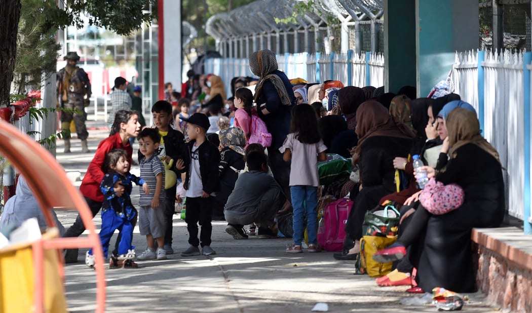 A Taliban Badri fighter, a "special forces" unit, stands guard as Afghans hoping to leave Afghanistan wait at the main entrance gate of Kabul airport in Kabul on August 28, 2021,